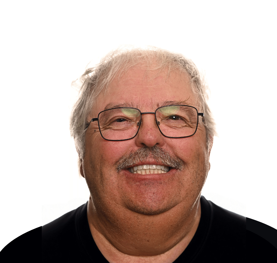 'http://An%20older%20man%20with%20gray%20hair%20and%20glasses%20is%20smiling%20at%20the%20camera.%20He%20has%20a%20mustache%20and%20is%20wearing%20a%20black%20shirt,%20with%20a%20plain%20white%20background%20behind%20him.